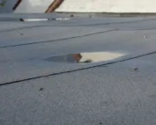 Flat roof drainage problem solutions. puddle of rain sitting on roof.
